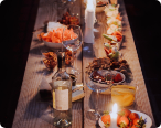 long table decorated with plates, food, and candles